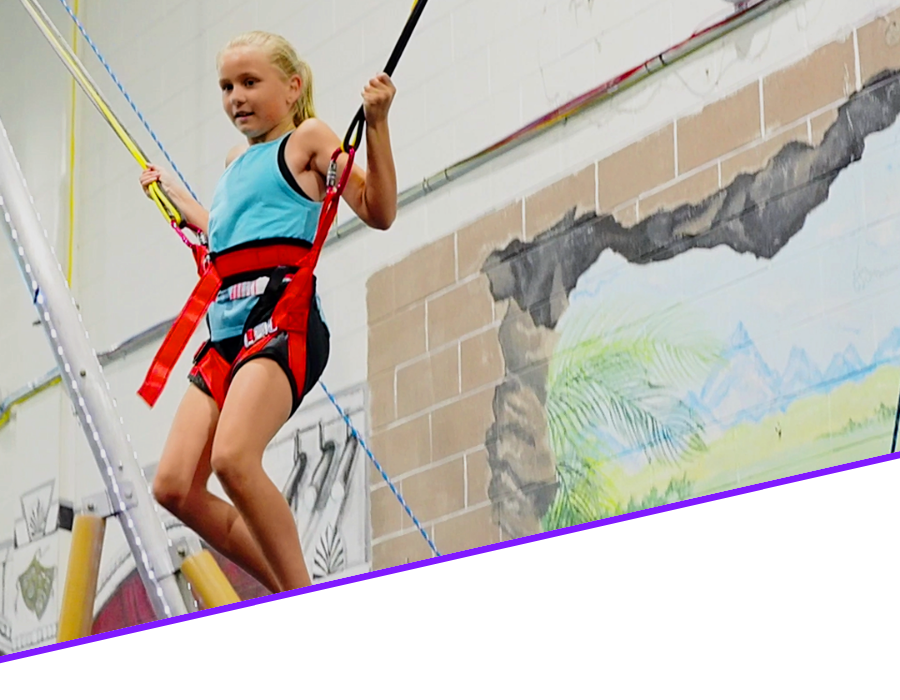 3 Exciting spiral tube slides in vibrant yellow and green colors, part of a large indoor playground structure, offering thrilling playtime experiences for kids.